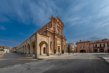 Fototapeta na wymiar Fossano, Cuneo, Italy: parish church of San Filippo (18th century) in piazza Aldo Nicolaj with the arcade and the buildings of the historic center