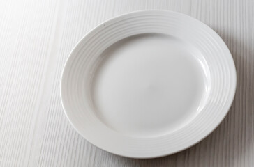 an empty white plate on a white table background