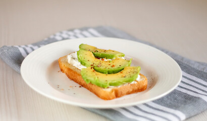 bruschetta with cream cheese and avocado in a plate on the table
