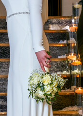 Cameo and candid shot of bride in beautiful, elegant and classic white wedding dress holding a...