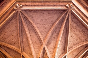 Closeup of a wooden frame of a ceiling, highlighting the intricate details of the woodwork