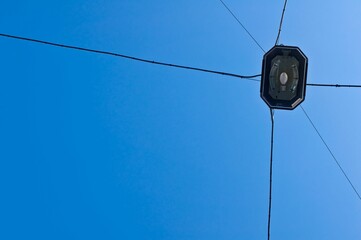 Obraz premium Street light and multiple electrical power lines extending into the distance captured from below