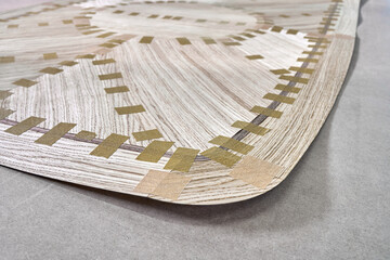 Jointed veneer with tape for tabletop of dining table with geometric pattern on workbench in workshop closeup
