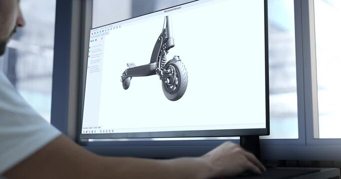 An engineer reviews the assembly of an electric scooter created in CAD - Computer-aided design software.