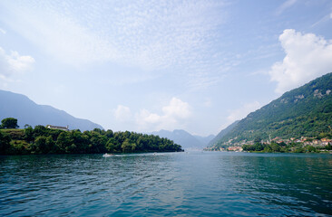 Beautiful scene of lake Como in Italy. A big blue lake surrounded by green hill.