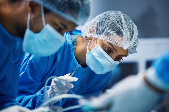 Hospital knife, surgery and doctors in theatre for medical support, teamwork and emergency healthcare with focus. Doctor, nurse and surgeon face mask, patient check and tools in operating room