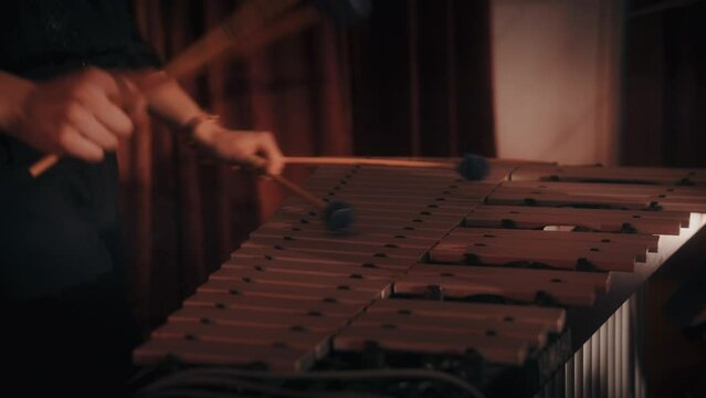 Closeup video of a woman playing marimba with wooden bars