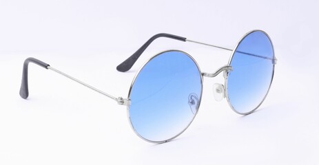 Isolated shot of a pair of round sunglasses with blue tinted lenses against a white background