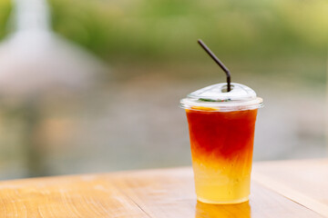 Lemon tea in plastic glasses with straws on the table. Copy space.