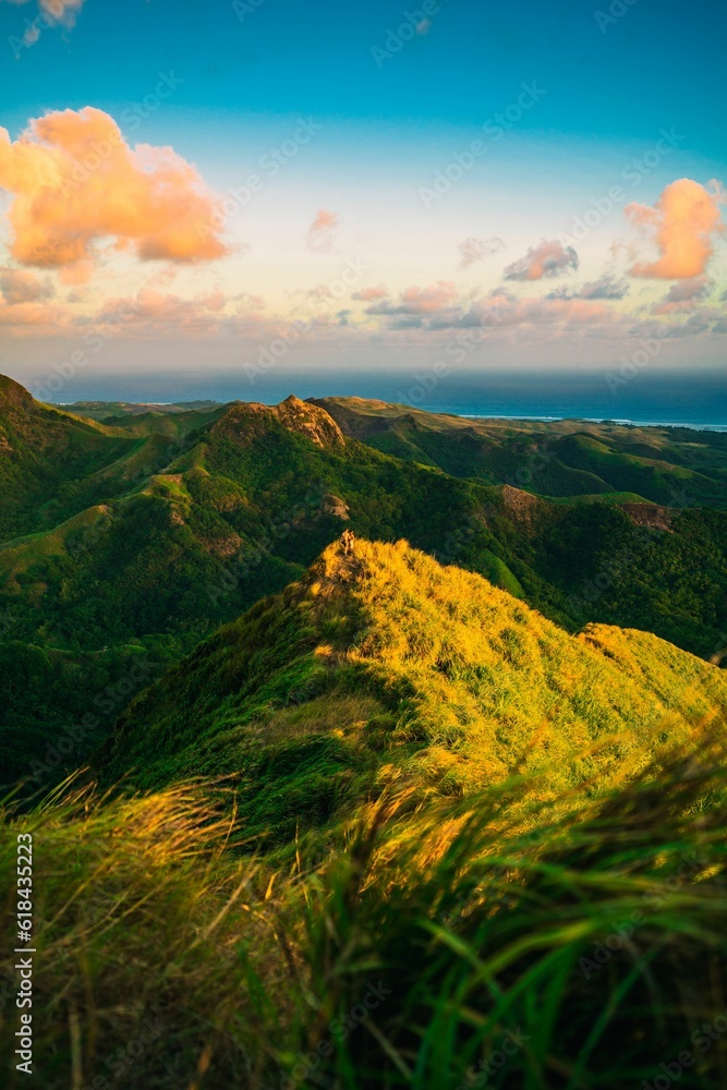 Sticker Scenic view of a mountain range at sunset with the blue ocean visible in the background, Guam