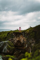 Fototapeta na wymiar Pink lighthouse on a cliff overlooking the vast ocean in Saipan