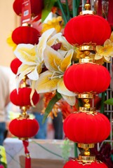 Closeup image of a set of traditional red lanterns adorned with delicate flowers
