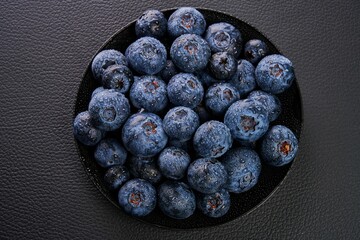 Closeup shot of a black ceramic plate with fresh organic blueberries from the Ecuadorian highlands.