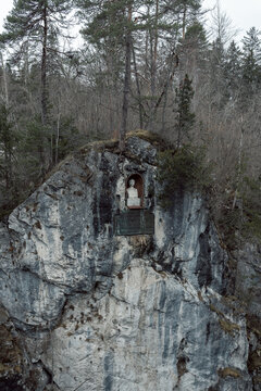 a statue in the mountain near the lech falls in füssen, taken in winter in the south of bavaria germany