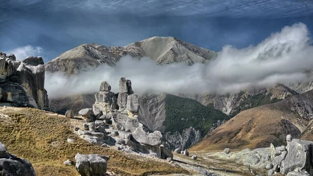 Time-lapse pf low clouds flying over the big mountains during the daytime