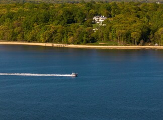 Aerial view over the calm waters with a sailboat traveling in Oyster Bay near Lloyd Harbor, New York