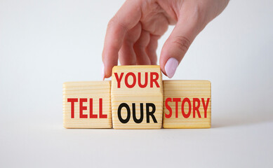 Tell Your or Our story symbol. Businessman hand turns wooden cubes and changes the words Tell Our story to Tell Your story. Beautiful white background. Business concept. Copy space