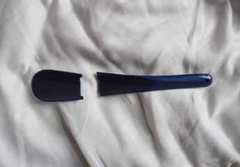broken shoehorn on bed sheet