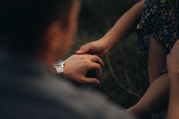 Happy young couple posing in a sun-drenched meadow at sunset.