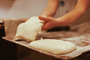Baker working in the kitchen, preparing loaves of bread