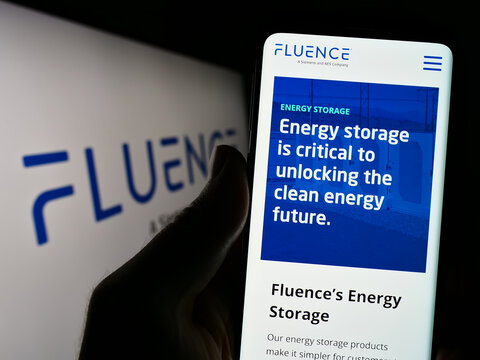 Stuttgart, Germany - 06-18-2023: Person holding cellphone with webpage of US company Fluence Energy LLC on screen in front of business logo. Focus on center of phone display.