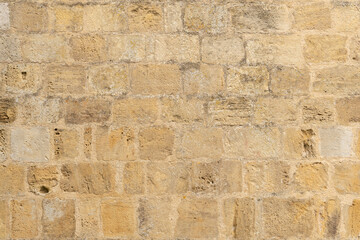 Light brown yellow dry stone wall texture, sandstone, medieval french wall, Pressac, France