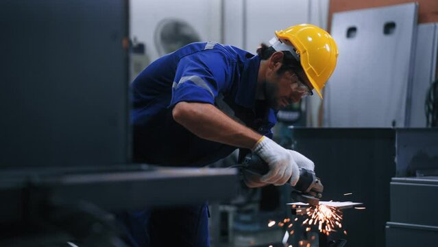 Worker man using grinding machine and cutting steel have spark from the grinding wheel at production factory industrial. Expert Man working hard in steel manufacturing plant. Factory industry concept