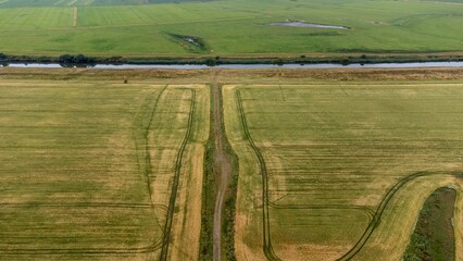 Aerial view of a canal flowing through green fields. Romo, Denmark