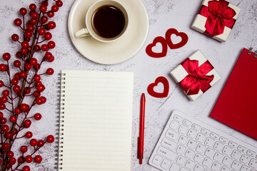 Red working items concept with flowers, red hearts, coffee and notebook on a grey marble background. 