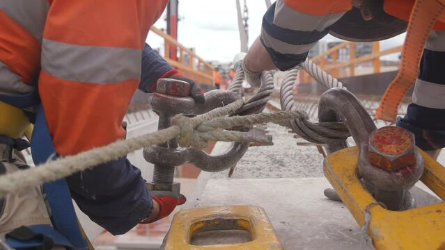 Slow-motion view of people tying a metallic rigging