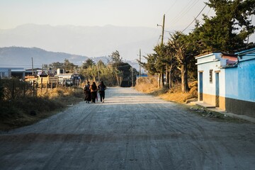 People making their way along a street in a rural setting