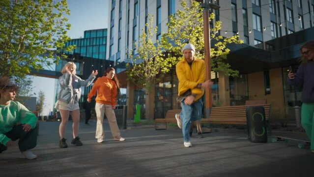 Slow Motion: Young And Athletic B-Boy Breakdancing To Break Beats On The City Street Among Modern Buildings In Circle Of Friends. Group Of Fashionable People Supporting, Live Streaming Via Smartphone.