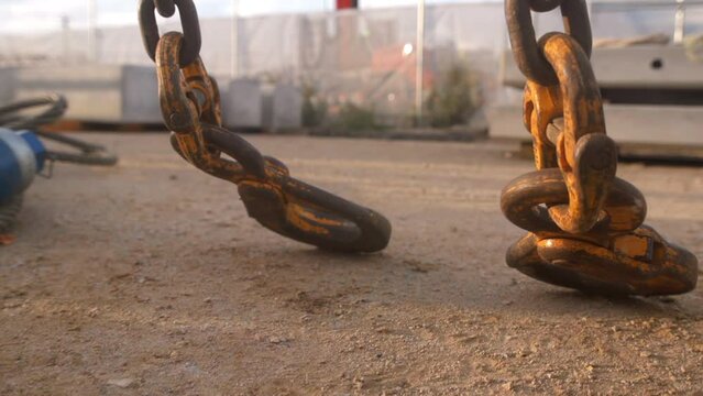 Slow-motion view of rusty hook chains lifting up