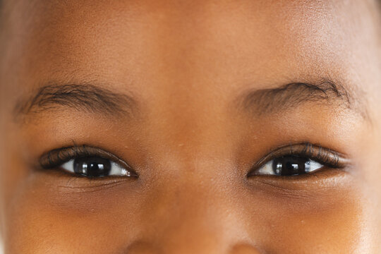 Close up of eyes of happy african american girl looking at camera