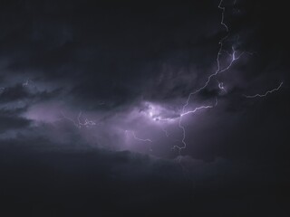 Beautiful shot of striking lightning in a dark purple sky