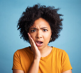 Confused, surprise or portrait of black woman with hand on face in shock, doubt or omg expression for announcement on studio background. Emoji, person and shocked reaction for news, story or gossip