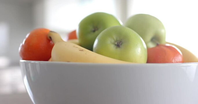 Close up of fruit in white bowl on countertop in kitchen