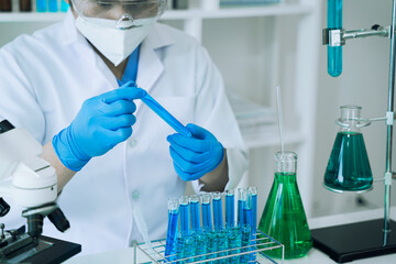 Science and medicine, scientist analyzing and dropping a sample into a glassware, experiments containing chemical liquid in laboratory on glassware, innovative and technology.