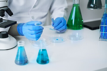 Science and medicine, scientist analyzing and dropping a sample into a glassware, experiments containing chemical liquid in laboratory on glassware, innovative and technology.