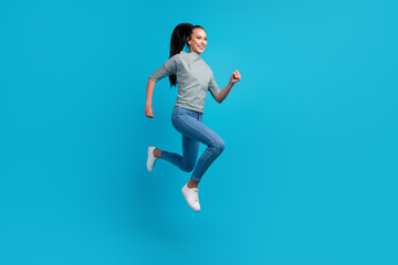 Photo of pretty charming woman dressed outfit jumping high running fast empty space isolated blue color background