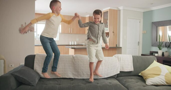 Funny, kids and boys on a couch, jump and energy with holiday, stress relief or holding hands. Male children, sofa or friends with joy, vacation or motion with activity, lounge or fun in an apartment