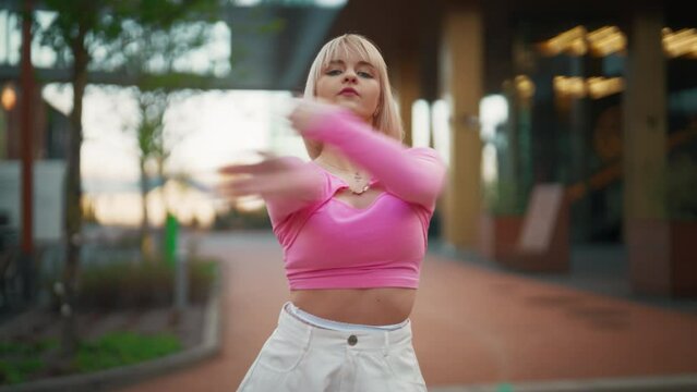 Following Shot Of Beautiful And Fashionable Young Caucasian Woman Wearing Pink Outfit And Voguing On City Street. Vogue Dancer Practicing Choreography During The Day. Preparing For The Vogue Ball.