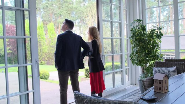 Blonde property manager talks with businessman about residence offer from estate management company. Client shares house preferences