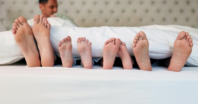 Bed, feet and family relax, calm and sleeping on holiday, hospitality and rest at home. Mother, father and parents with children, kids or weekend nap on holiday, bedroom or bonding with love and toes