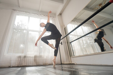 A beautiful Asian woman is dancing at the barre. Ballet dancer.