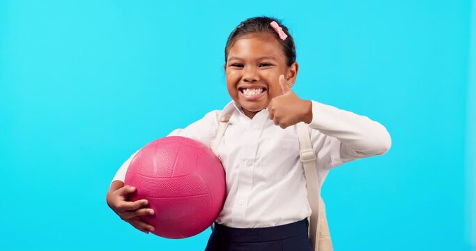 Happy, sports and child with a thumbs up on a blue background for school activities and netball. Smile, success and face portrait of student with a gesture for training isolated on a studio backdrop
