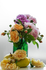 Close-up, colorful large bouquet of garden summer fragrant flowers on a light background in a green vase