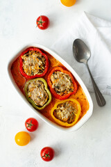 Baked bell pepper with meat and rice in a ceramic bowl on a light background. Stuffed pepper, halves of peppers stuffed with meat and rice, biber dolmasi
