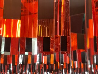Abstract pattern and design of glass wall of rectangular panes of black red orange glass window at different angles in modern building day with reflections 