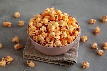 Homemade Cheese Popcorn in a Bowl on a gray background, side view.